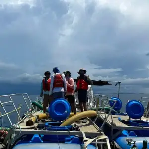 Crew in life jackets on a work boat at sea