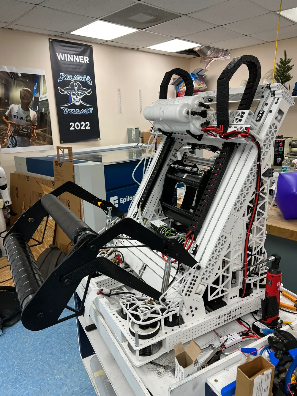 The robot mid-build on a cart in the team workshop, intake arm extended