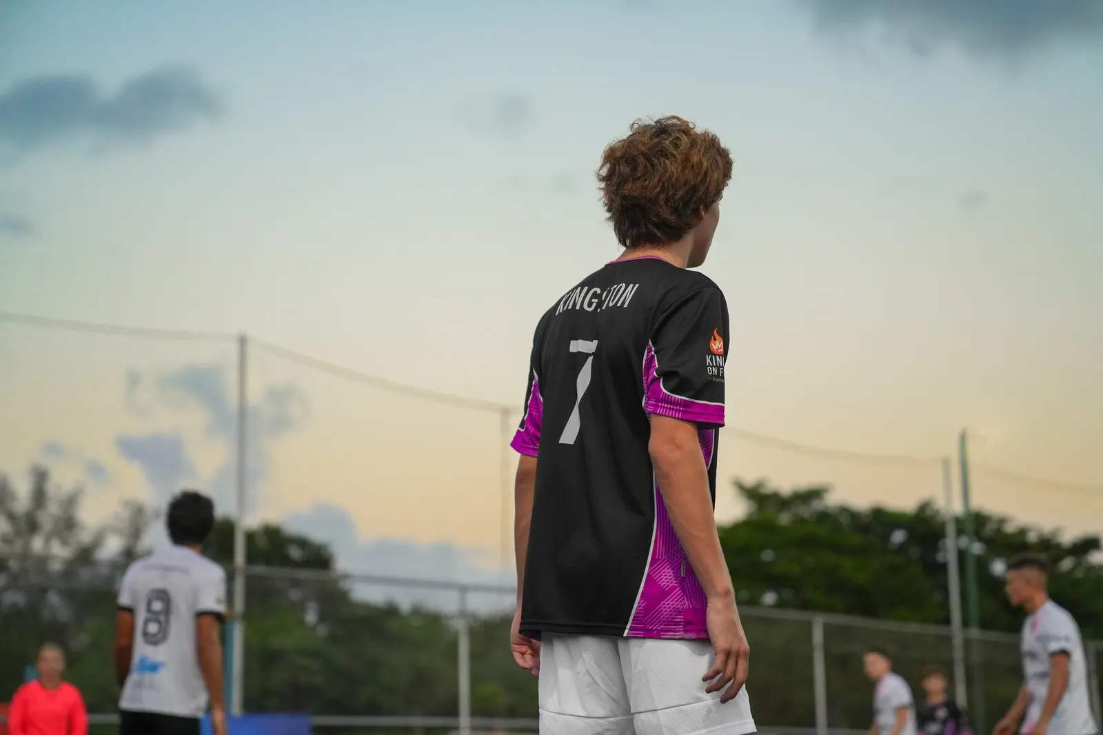 Player in a number 7 jersey seen from behind at dusk