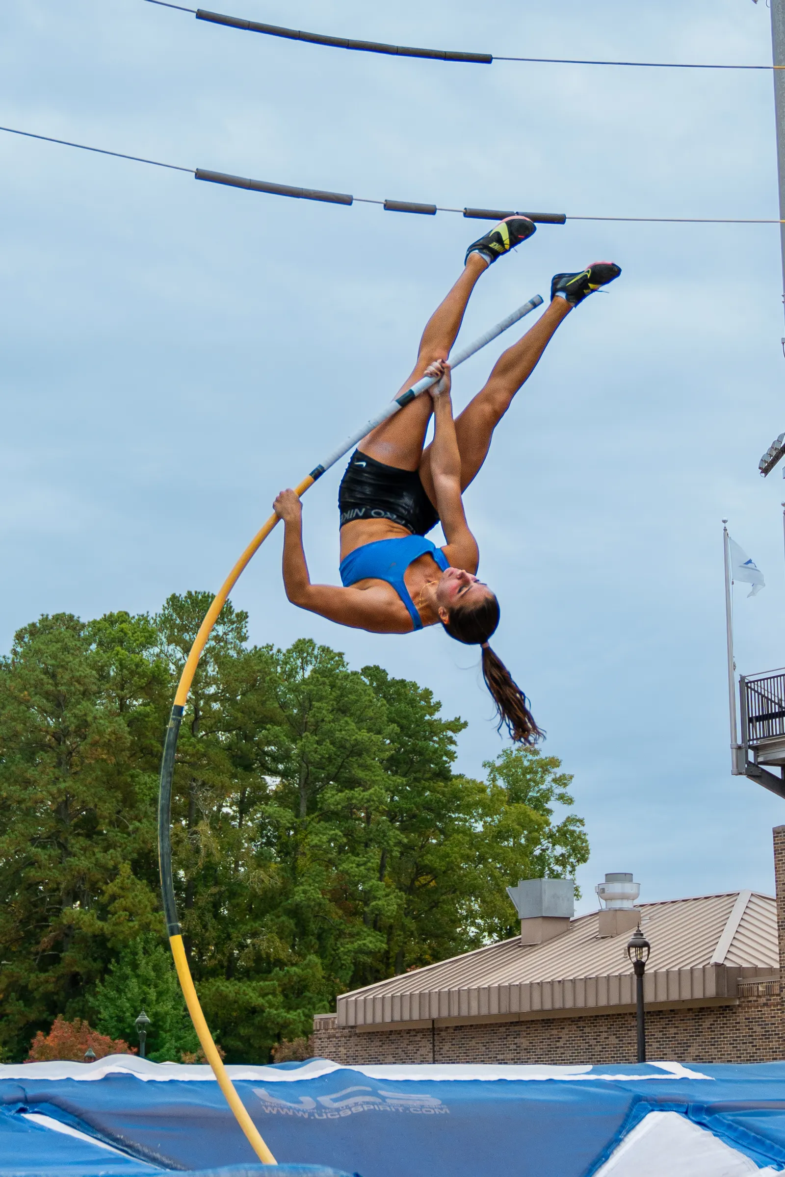Pole vaulter inverted on a bent pole