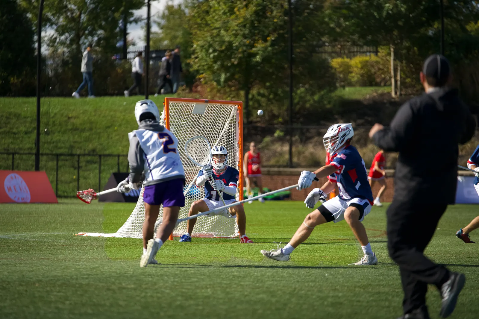 Lacrosse players battling in front of the goal