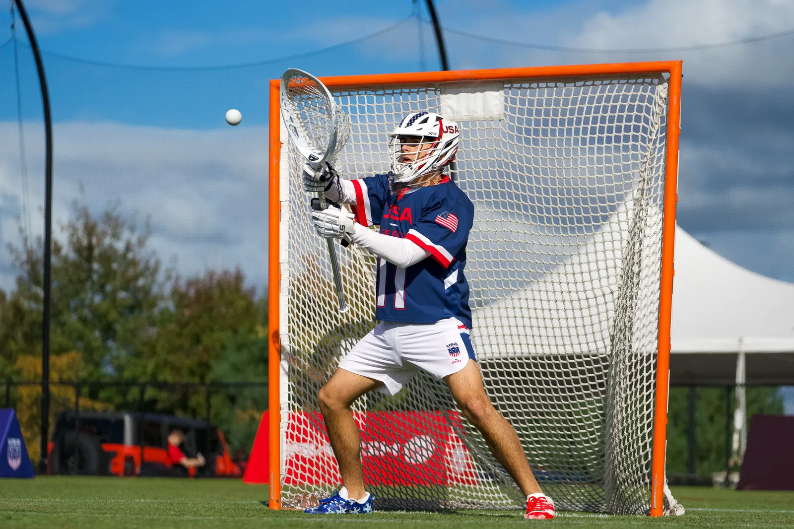 Lacrosse goalie making a save with the ball in the air